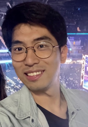 A person wearing glasses and smiling

Description automatically generated