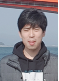 A person standing in front of water
Description automatically generated